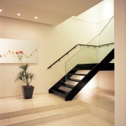 A window in the void of the stairwell architecture, ceiling, daylighting, floor, flooring, glass, handrail, interior design, lobby, product design, real estate, stairs, tile, orange