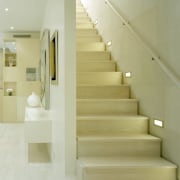 The white-on-white interior provides a tranquil refuge from architecture, daylighting, floor, flooring, handrail, home, interior design, laminate flooring, lobby, product design, stairs, tile, wall, wood flooring, yellow, orange