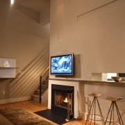 view of kitchen and living area, featuring cabinetry, ceiling, fireplace, floor, hearth, home, interior design, living room, brown