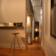 view of kitchen and living area, featuring cabinetry, floor, flooring, interior design, light fixture, lighting, loft, wood, brown, orange