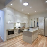 A view of a kitchen designed by a cabinetry, ceiling, countertop, floor, flooring, hardwood, interior design, kitchen, laminate flooring, real estate, room, wood flooring, gray