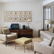 Many of the furnishings were collected by one couch, floor, furniture, home, interior design, living room, loveseat, room, table, wall, window, gray