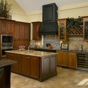A simple door style and stacked appliances complement cabinetry, countertop, cuisine classique, hardwood, interior design, kitchen, room, brown, orange