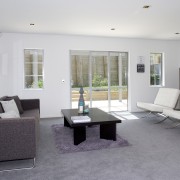 Living area inside contemporary townhouse created by Le architecture, floor, flooring, furniture, house, interior design, living room, property, real estate, room, table, gray, white