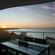 Large balconies allow homeowners to enjoy views of apartment, evening, home, property, real estate, sea, sky, sunrise, sunset, window, black, gray