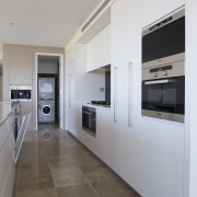 View of kitchen which features microwave combi oven, architecture, countertop, floor, interior design, kitchen, real estate, gray