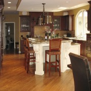 A more traditional look was specified for this cabinetry, countertop, cuisine classique, dining room, floor, flooring, furniture, hardwood, home, interior design, kitchen, laminate flooring, room, table, wood, wood flooring, wood stain, brown, red