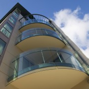 Curved glass balustrades help to maximise views from architecture, building, commercial building, daylighting, daytime, facade, glass, sky, structure, teal