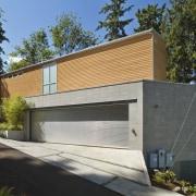 The mid-level garage extends beyond the triangular footprint architecture, building, elevation, facade, home, house, property, real estate, residential area, siding, brown, gray, black