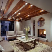 The living room ceiling features exposed beams. Custom ceiling, hardwood, home, interior design, living room, real estate, room, gray, brown