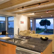 Glass sliding doors provide a connection between the countertop, estate, interior design, living room, real estate, room, window, wood, brown