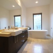 Bathroom, featuring vanity with dark-stained timber cabinetry and bathroom, daylighting, estate, floor, flooring, home, interior design, real estate, room, sink, gray