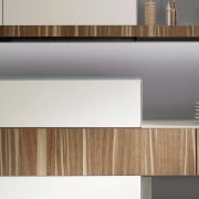 This emotoin kitchen features glossy white cabinetry with floor, furniture, line, product design, shelf, wall, wood, white, gray