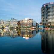 Victoria Harbour comprises the largest area in Docklands building, city, cityscape, condominium, daytime, downtown, metropolis, metropolitan area, mixed use, real estate, reflection, sky, skyline, skyscraper, tower block, urban area, water, waterway, teal