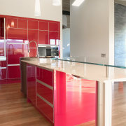 The breakfast bar has a raised glass top cabinetry, countertop, cuisine classique, floor, flooring, hardwood, interior design, kitchen, laminate flooring, real estate, room, wood flooring, red, white