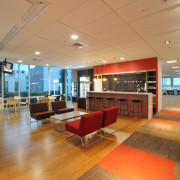 The BNZ has many waiting rooms located around ceiling, floor, flooring, institution, interior design, lobby, real estate, orange, brown