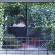 View of the rear side of the house architecture, door, facade, fence, gate, glass, home, house, property, real estate, residential area, sash window, shade, tree, wall, window, window screen, window treatment, yard, black