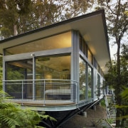 This modern tree house is set in the architecture, cottage, facade, home, house, real estate, window, brown