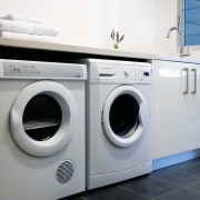 The laundry features Fisher &amp; Paykel washer and clothes dryer, home appliance, laundry, laundry room, major appliance, product, product design, washing machine, gray