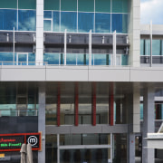 View of an office building featuring glazing which apartment, architecture, building, commercial building, condominium, corporate headquarters, facade, headquarters, metropolitan area, mixed use, real estate, residential area, window, black, gray