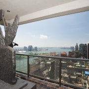 View of balcony looking out over city with apartment, building, city, condominium, metropolis, metropolitan area, property, real estate, skyscraper, window, gray, black