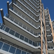 Exterior view of the Evolve apartment buildings which apartment, architecture, building, commercial building, condominium, corporate headquarters, daytime, facade, headquarters, metropolis, metropolitan area, mixed use, property, real estate, residential area, sky, skyscraper, tower block, gray, black