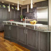 The placement of the island was confined by cabinetry, countertop, cuisine classique, floor, flooring, hardwood, interior design, kitchen, room, wood flooring