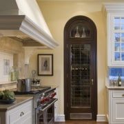 It is the fine millwork and attention to cabinetry, ceiling, countertop, cuisine classique, floor, hardwood, home, interior design, kitchen, room, window, wood flooring, brown, gray, orange