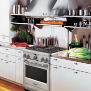 View of a kitchen which features a range, cabinetry, countertop, cuisine classique, gas stove, home appliance, interior design, kitchen, kitchen appliance, kitchen stove, major appliance, microwave oven, oven, refrigerator, small appliance, white