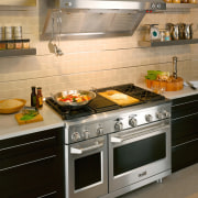 View of a kitchen which features a range, countertop, gas stove, home appliance, kitchen, kitchen appliance, kitchen stove, oven