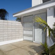 A prominent wall blocks the view of passer-by architecture, door, estate, facade, home, house, property, real estate, residential area, siding, window, gray