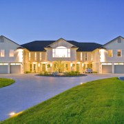 While the formal entrance to the house is building, cottage, elevation, estate, facade, farmhouse, home, house, lighting, mansion, property, real estate, residential area, roof, sky, suburb, villa, window, blue