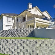 Retaining walls follow the contours of the site. architecture, building, cottage, daytime, elevation, estate, facade, home, house, mansion, property, real estate, residential area, roof, sky, suburb, villa, wall, blue
