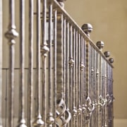 The grand staircase features wrought iron balustrades that baluster, handrail, iron, material, metal, stairs, brown, orange, gray