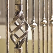 The grand staircase features wrought iron balustrades that brass, iron, metal, brown