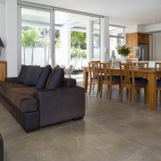 The slate tones of the interior flooring relate floor, flooring, furniture, hardwood, interior design, living room, property, real estate, table, wood, wood flooring, gray