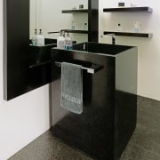 This powder room features a unique rectangular handbasin countertop, floor, flooring, furniture, product design, sink, table, tap, black, gray