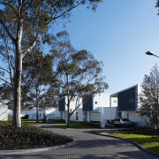 View of the exterior of the town houses architecture, building, corporate headquarters, daytime, estate, facade, home, house, neighbourhood, property, real estate, residential area, sky, tree, black