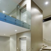 The stairs wrap around a central lift core, architecture, ceiling, daylighting, floor, glass, handrail, house, interior design, lighting, real estate, stairs, wall, gray