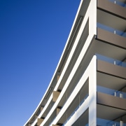 Exterior view of the Flow Apartments which sit apartment, architecture, building, commercial building, condominium, corporate headquarters, daylighting, daytime, facade, headquarters, line, metropolitan area, mixed use, sky, tower block, blue