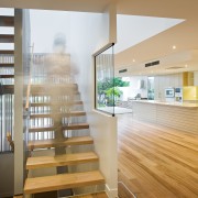 View of a stairway in the Flow Apartment apartment, ceiling, daylighting, floor, flooring, handrail, hardwood, home, house, interior design, real estate, stairs, wood, orange