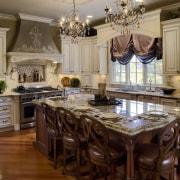 View of a kitchen which is centrally located cabinetry, ceiling, chandelier, countertop, cuisine classique, dining room, furniture, home, interior design, kitchen, room, table, brown