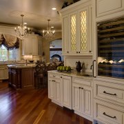 View of a kitchen which is centrally located cabinetry, countertop, cuisine classique, floor, flooring, hardwood, home, interior design, kitchen, laminate flooring, room, wood, wood flooring, brown, orange