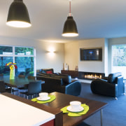 View of open-planned kitchen which features a kitchen ceiling, furniture, interior design, light fixture, lighting, living room, room, table, white