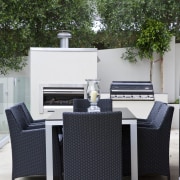 Image of the exterior of this home. Outdoor chair, furniture, outdoor structure, patio, table, wicker, white