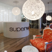 view of the reception area of the SuperWoman ceiling, interior design, lampshade, light fixture, lighting, lighting accessory, living room, room, table, wall, white