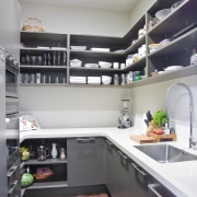 View of a kitchen which features ovens, refrigerator, cabinetry, countertop, interior design, kitchen, room, gray