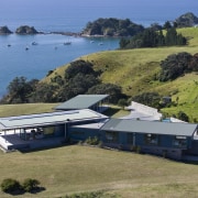 Image of the exterior of this beautifully designed aerial photography, bay, coast, cottage, estate, home, house, promontory, property, real estate, sea, terrain, brown, teal