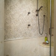 View of the shower enclosure which features embossed bathroom, floor, interior design, plumbing fixture, room, shower, tile, wall, orange, brown