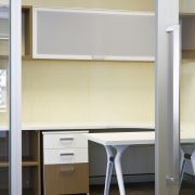 Interior view of an office which includes office chest of drawers, desk, furniture, interior design, office, product design, shelf, shelving, table, wall, gray